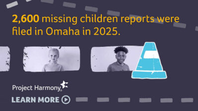 Graphic promoting Project Harmony’s Omaha Against Traffick campaign featuring the message, “2,600 missing children reports were filed in Omaha in 2025.” Black-and-white portraits of children appear alongside a blue traffic cone icon and the Project Harmony logo with a “Learn More” button, emphasizing child safety and abuse prevention.